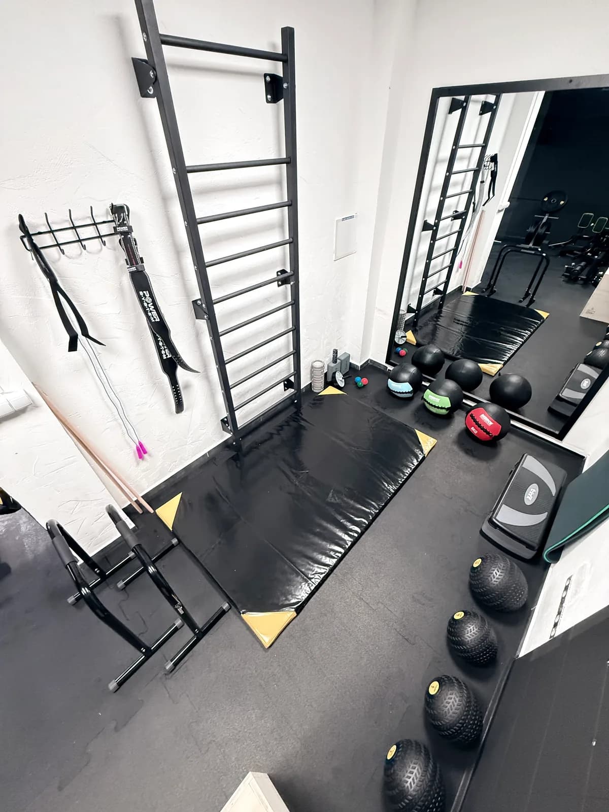 Priestor pri rebrinách so žinienkou a medicinbalmi v Limitless Gym