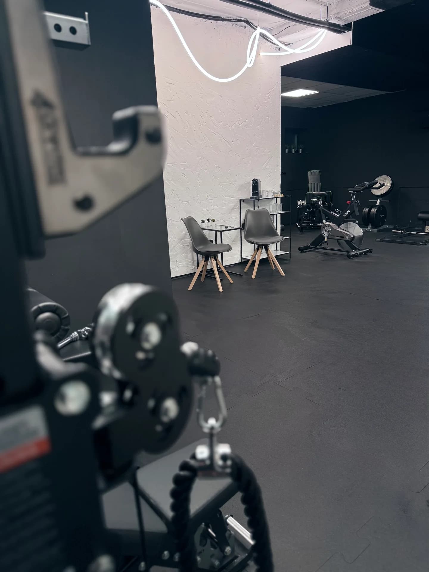 Pohľad cez tréningový priestor na oddychový kútik Limitless Gym